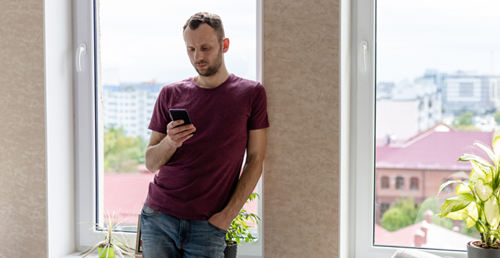 Man looking worriedly at mobile device