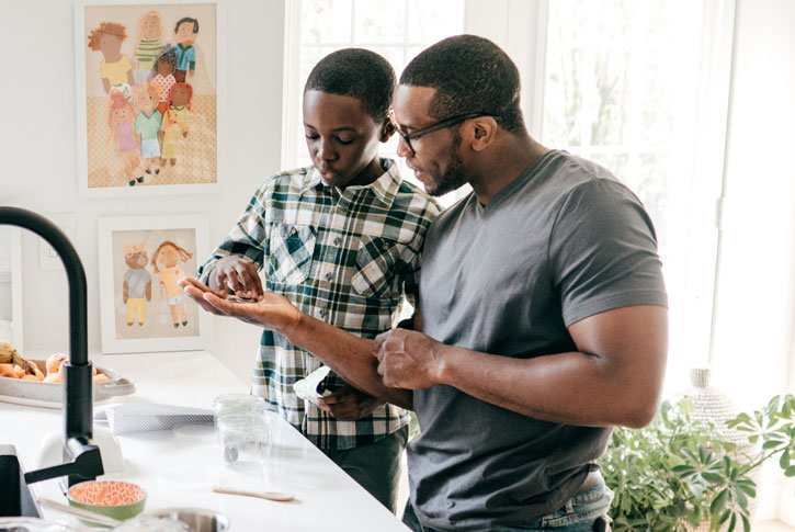 Father helping young son count his coins