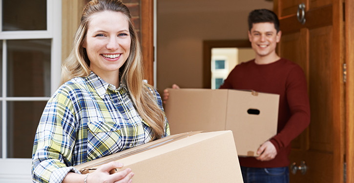 Young couple moving with boxes