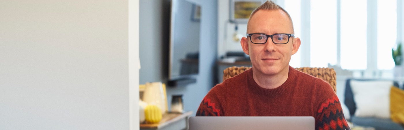 Smiling man sitting at laptop