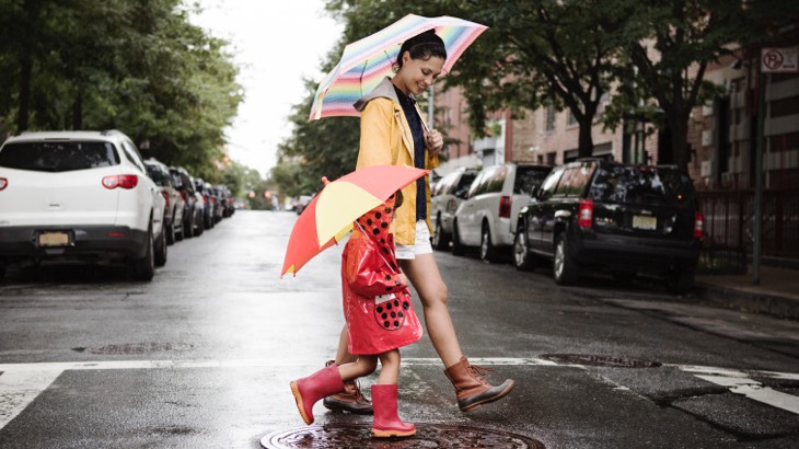 Mother and child walking in the rain with umbrellas