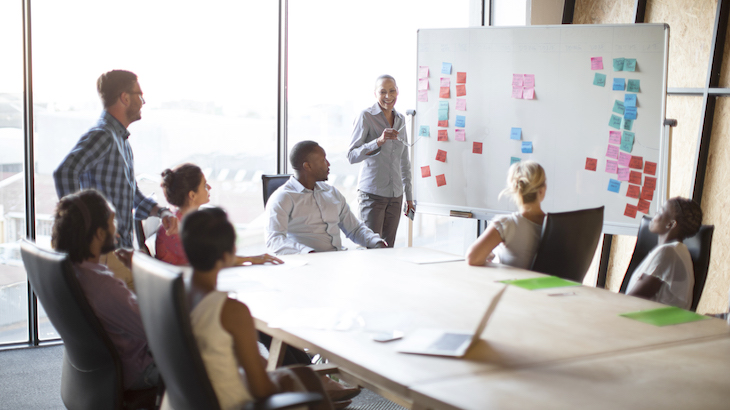 Young diverse team meeting round an executive table