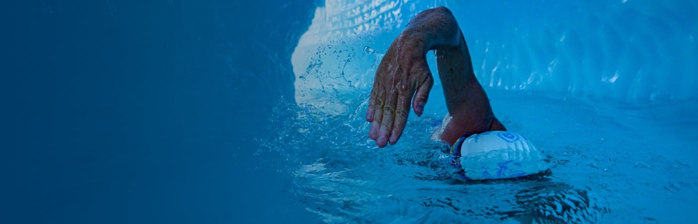 Lewis Pugh swimming in water in Greenland surrounded by a glacier