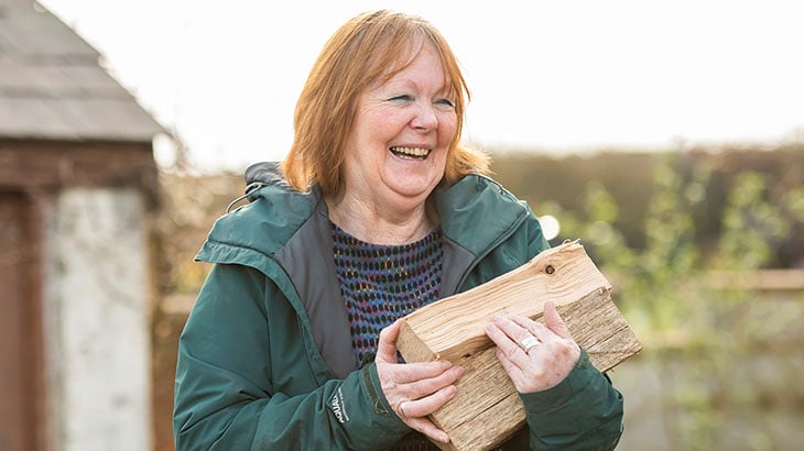 Smiling woman holding log