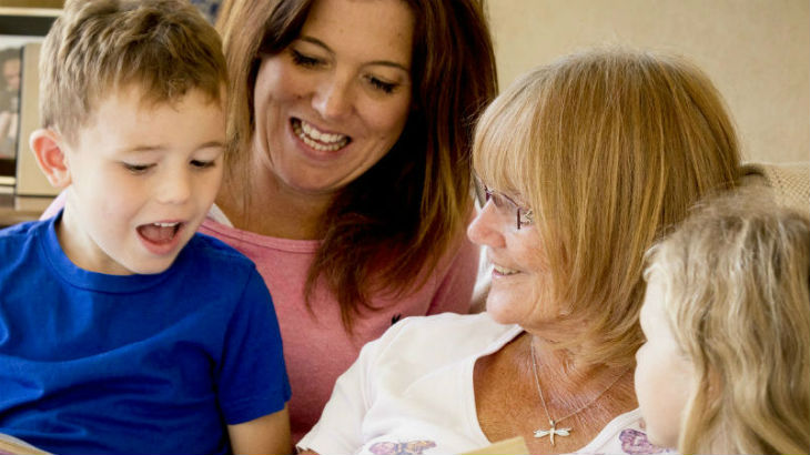 Two young children and two women smiling.