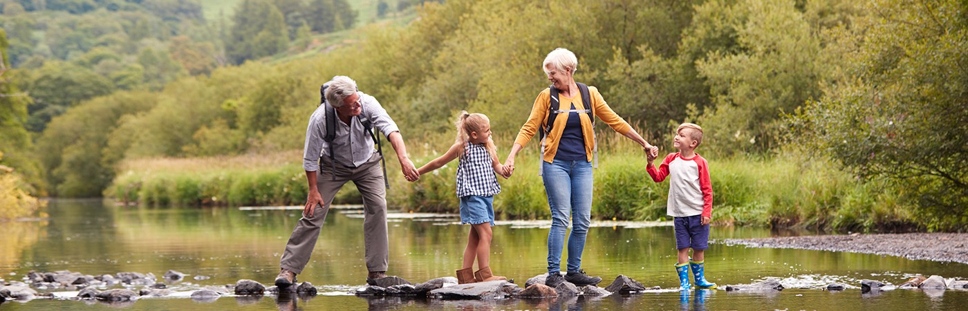 Family crossing a river on stepping stones
