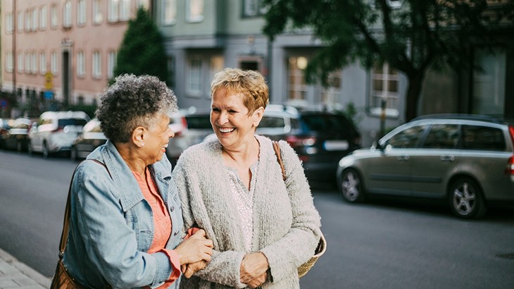 Two women chatting and laughing while walking
