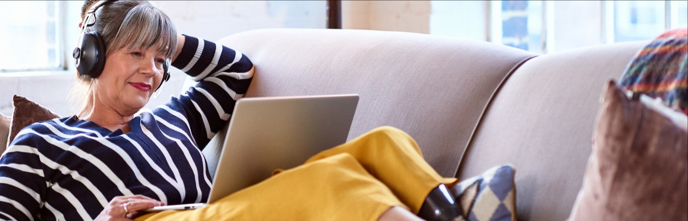 Lady on a sofa looking at a laptop