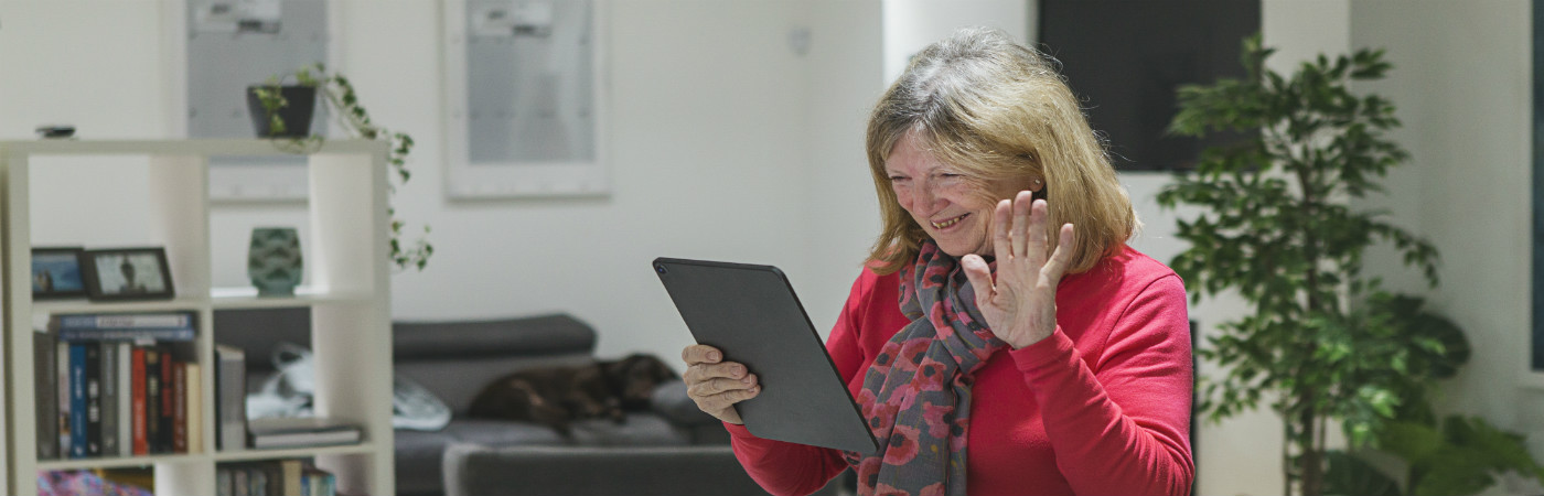 senior-woman-smiling-at-ipad-desktop.jpg