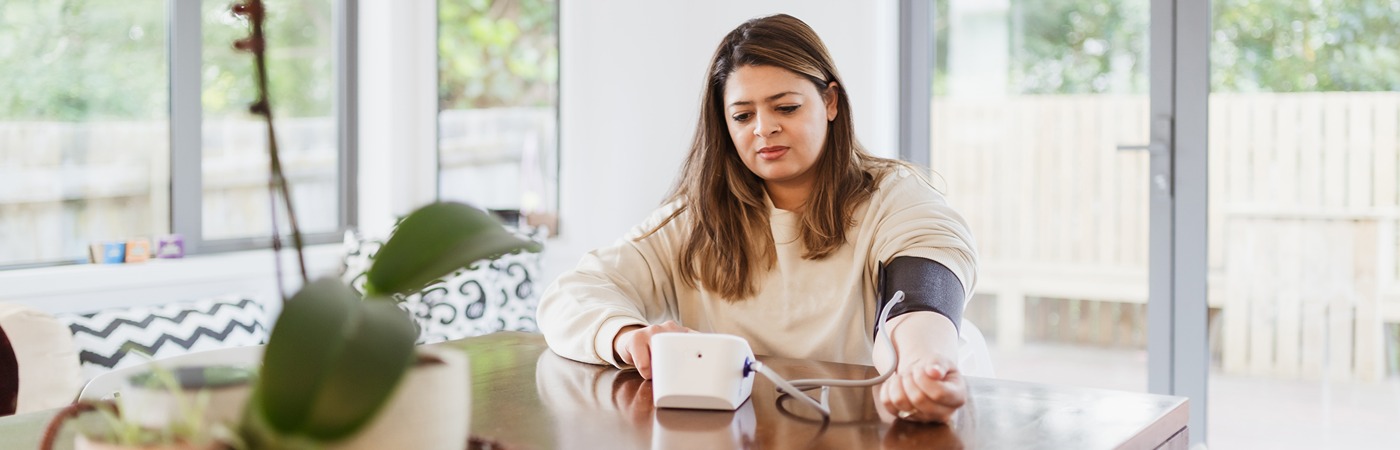 a woman taking her blood pressure at home