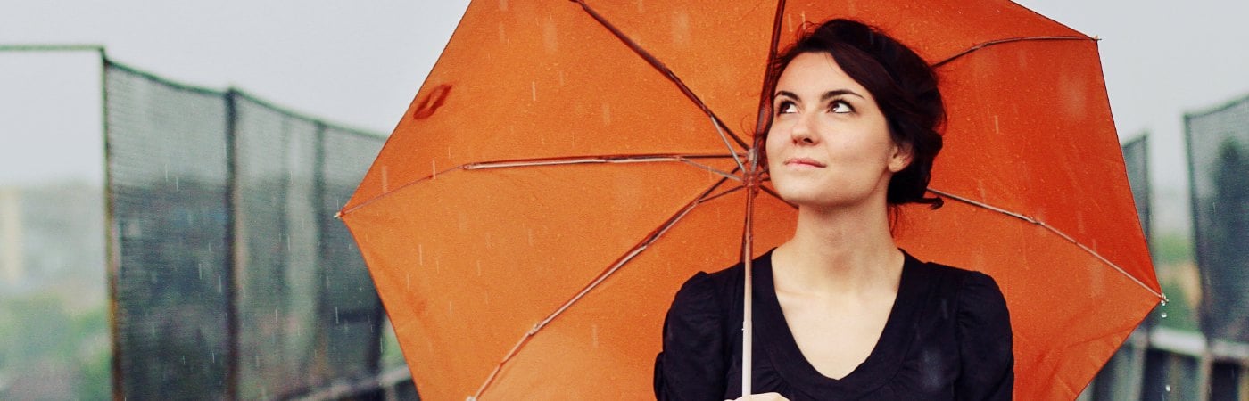 Image of woman with umbrella protecting herself in the rain