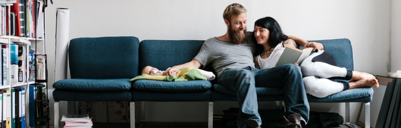 family with young baby sitting on the sofa