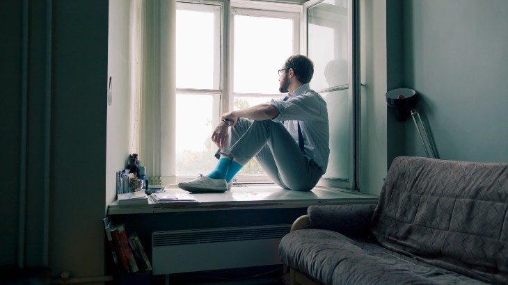 lonely man looking out of window