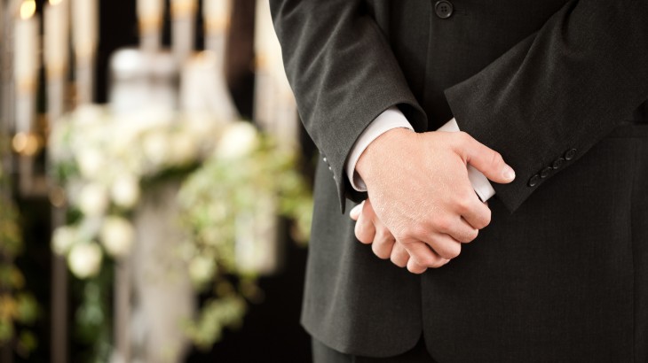 Funeral director standing with hands crossed