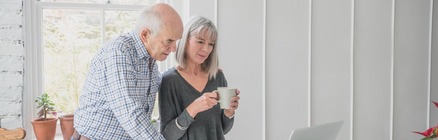 Senior man and woman looking at laptop