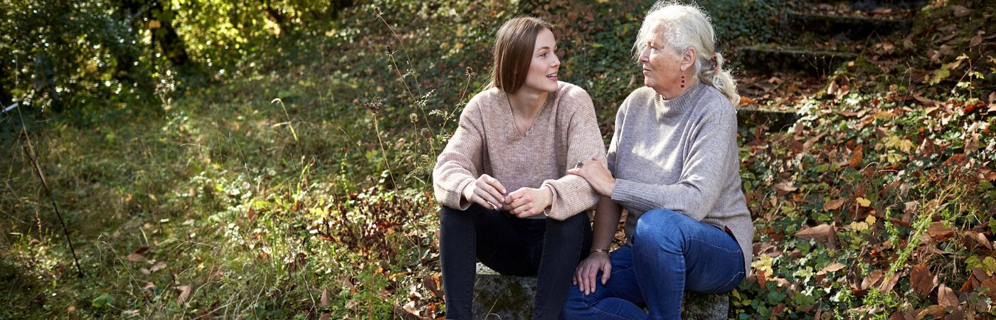 Young adult and older woman having a conversation outside