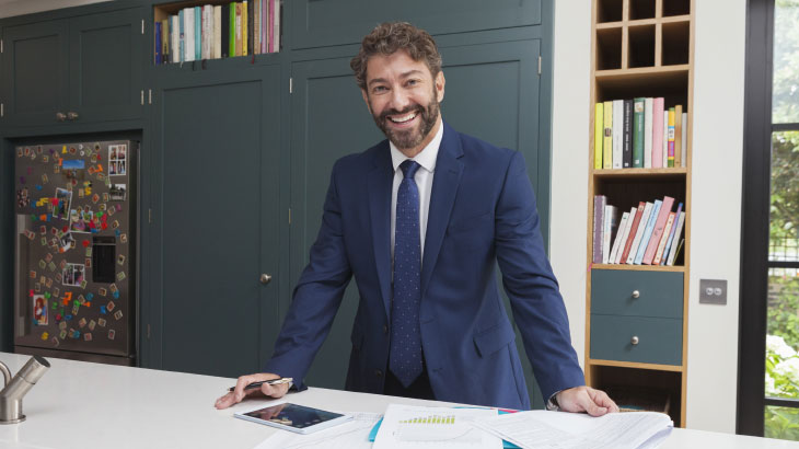 Man standing next to desk