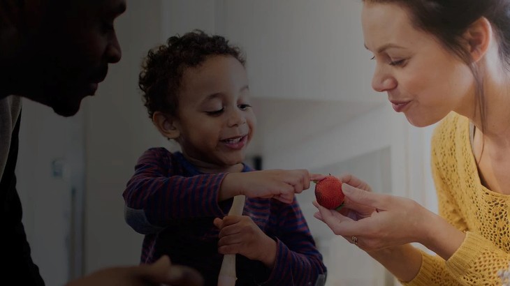 Family with child looking at fruit
