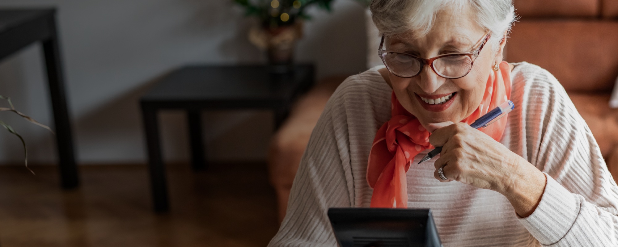 Mature lady thinking and holding a pen