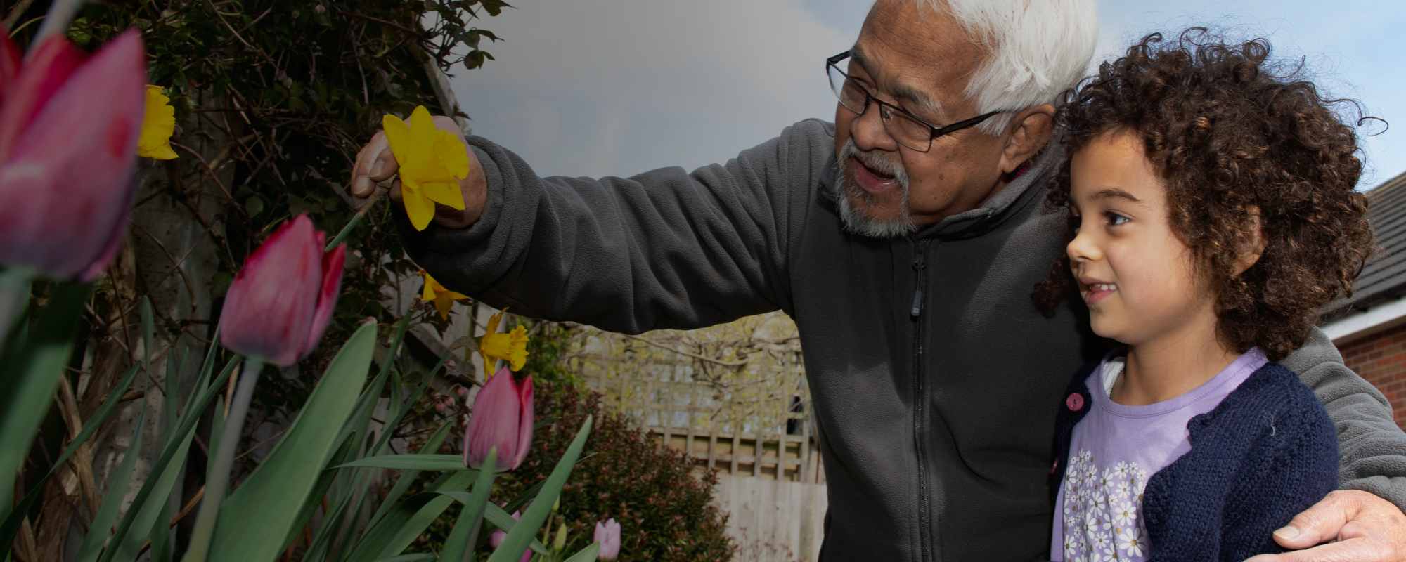 Granddad with granddaughter in garden