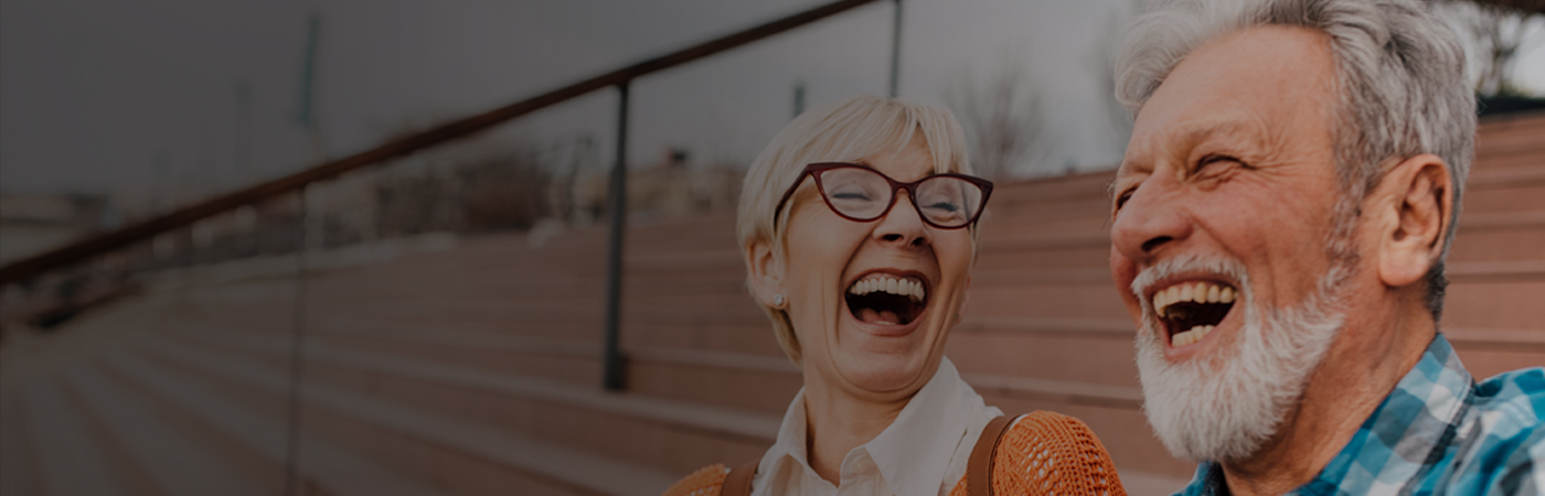 Older man and woman laughing outside