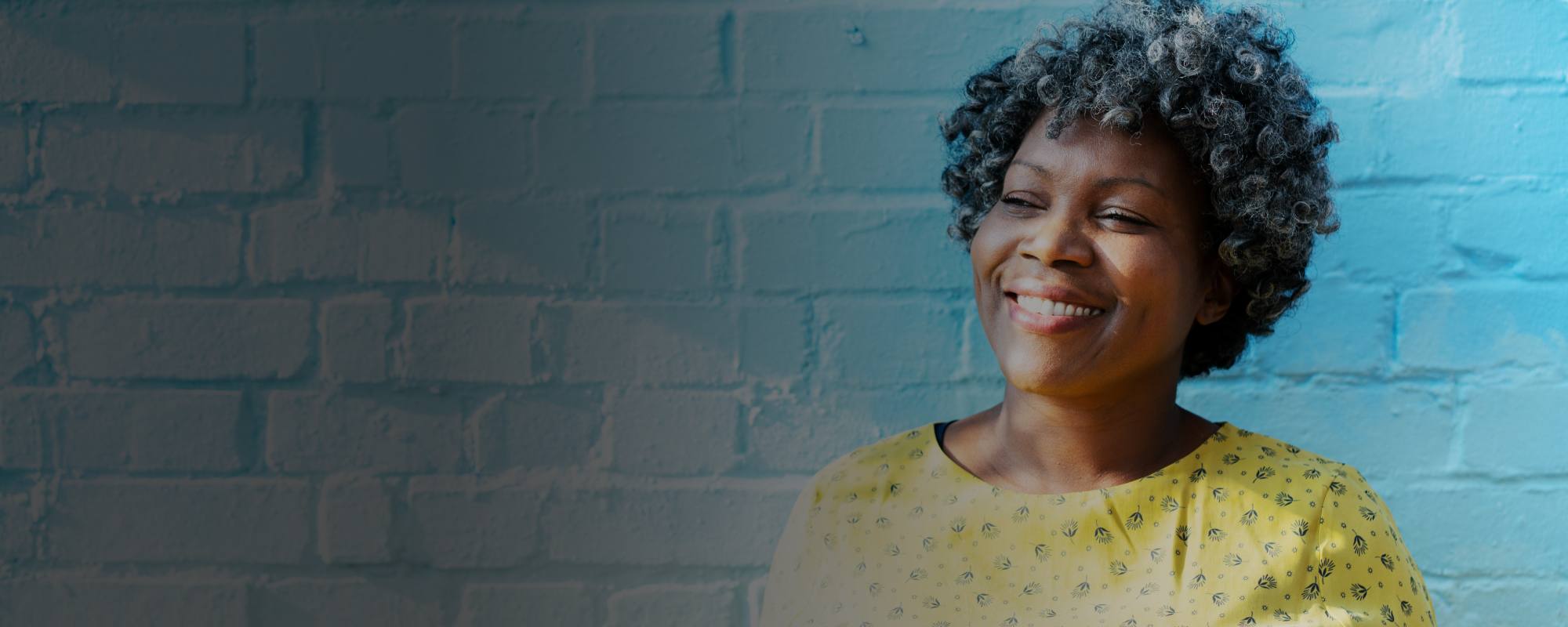Woman in front of a blue brick background